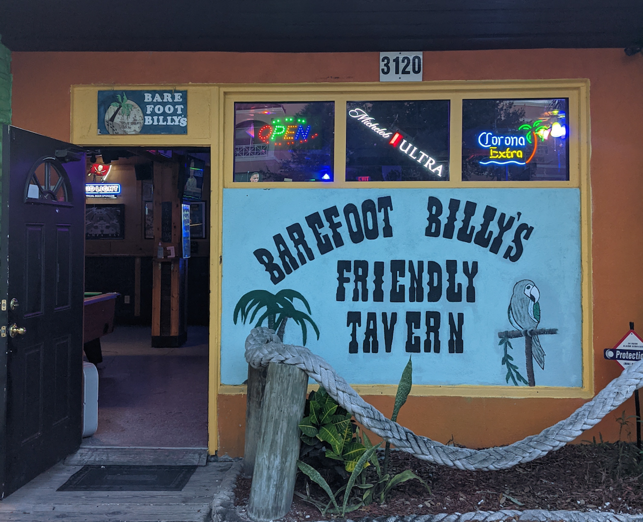 Barefoot Billy’s Friendly Tavern 
3120 W Gandy Blvd., Tampa, 813-831-8703
If you’re not careful you may drive right past the parking lot of this South Tampa watering hole on Gandy Blvd. From the street you’ll notice the outside of the bar is painted with tropical scenes of palm trees and a setting sun, but once inside you’ll find a dimly lit space with wood paneled walls and TVs to watch your favorite teams. While they offer beer and wine only, they do have flavored jello shots, which were deemed “strong as hell” by the bartender. A large patio area out back has plenty of picnic tables where you can enjoy your beer with your furry friend.
Photo by Jourdan Ducat