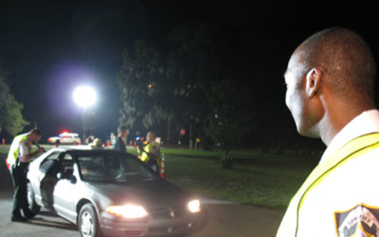 ROAD BLOCKED: Cpl. William Porter looks over a sobriety checkpoint operation on State Road 674 in Wimauma.