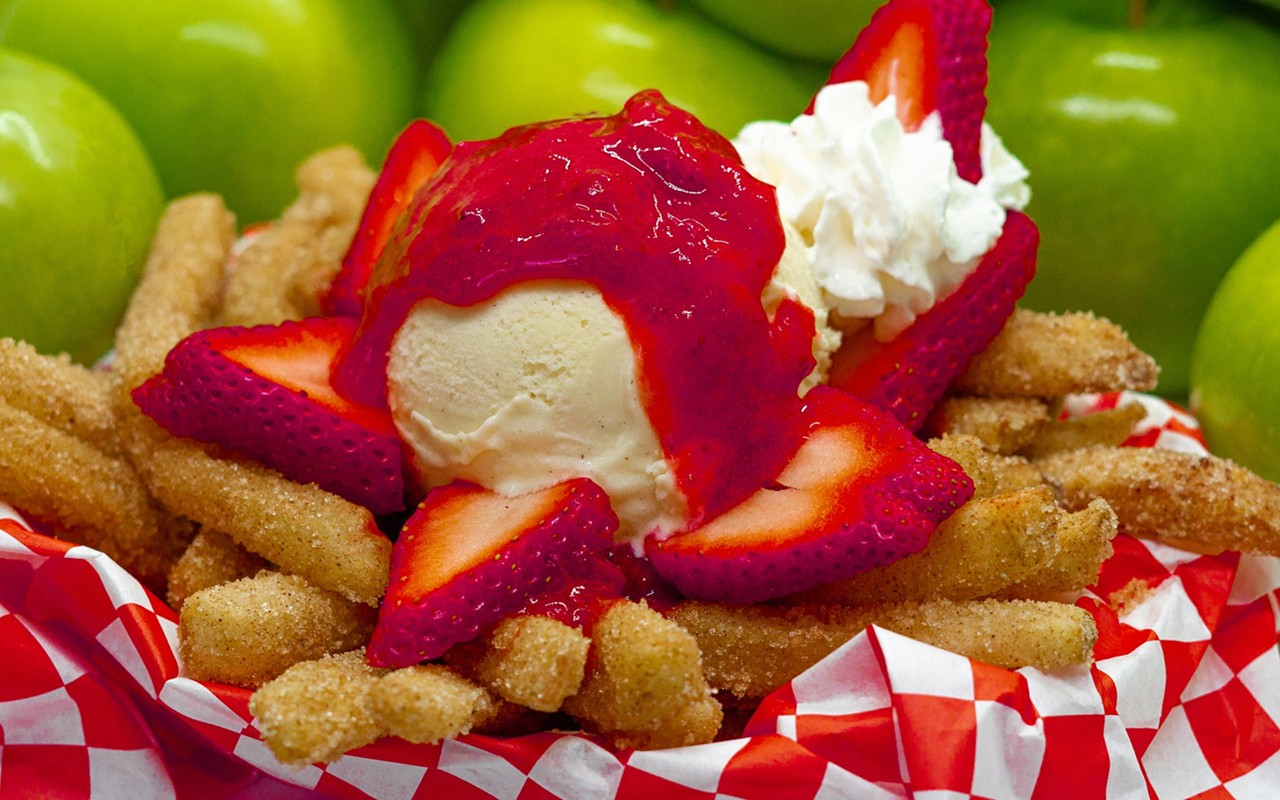 Apple fry sundae with strawberry compote, vanilla ice cream, fresh strawberries and whipped cream over crispy apple fries .