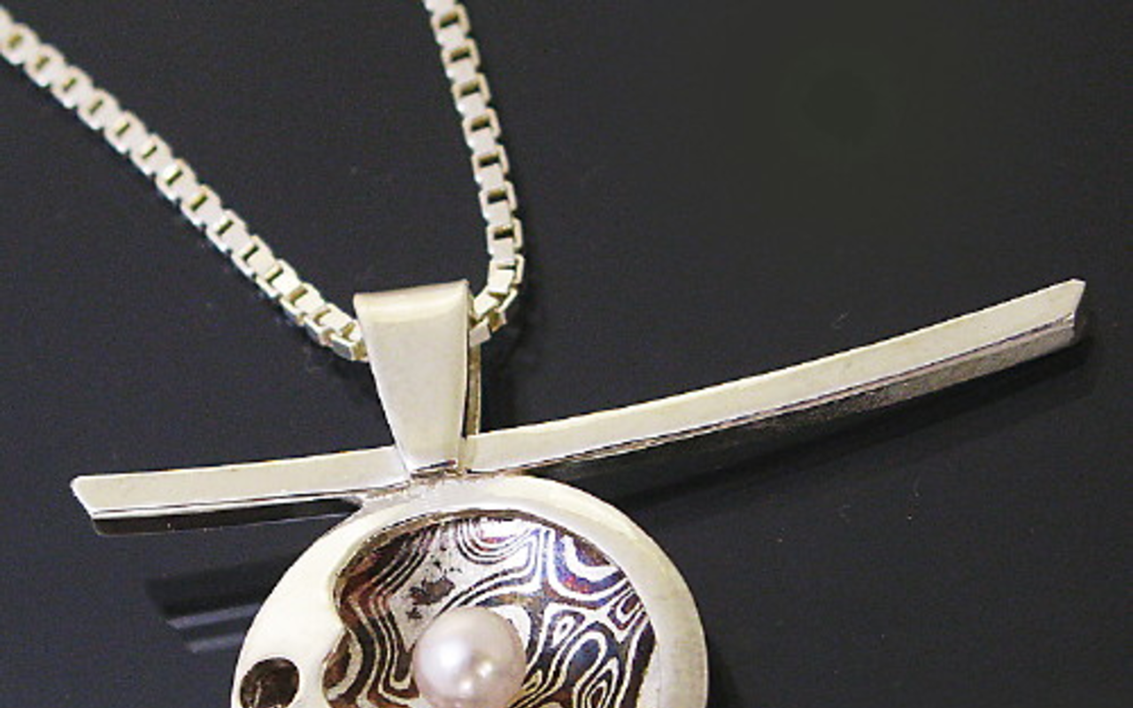 A pendant created by Singing Stone Gallery's Dan Balk is made of sterling silver, freshwater pink pearl and 20 alternating sheets of argentium steel and patinaed copper.