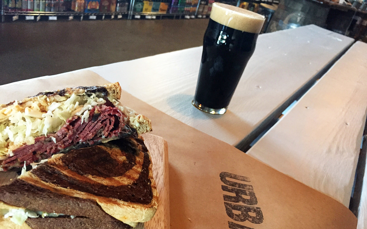 The kimchi Reuben features house-made pastrami, Napa cabbage dressed in kimchi vinaigrette, Urban Sweet and Smoky Sauce, and smoked Gouda on rye.