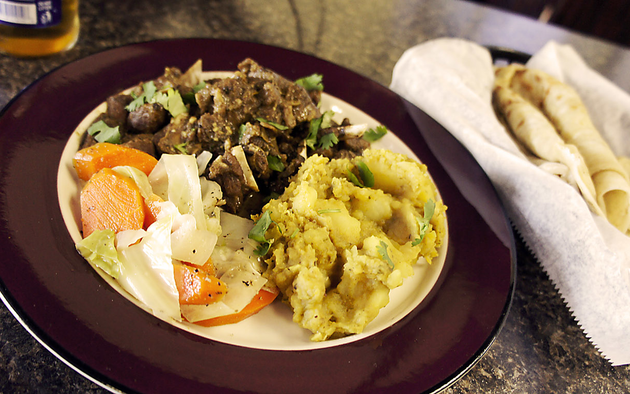RANDY’S ROTI: The open-faced curry goat with curry potatoes, steamed cabbage and a basket of homemade roti bread.