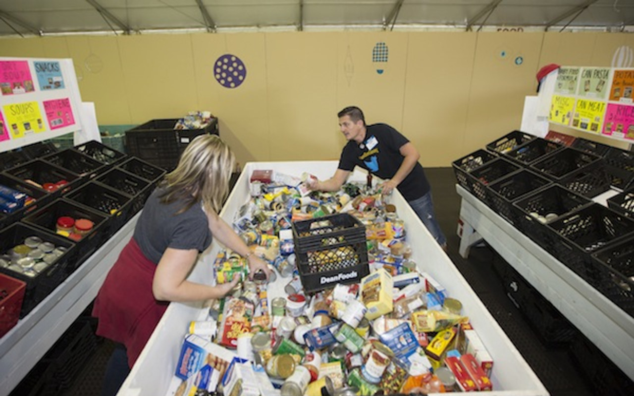 Volunteers sort food into bins at the Metropolitan Ministries Holiday Tent in Tampa Heights.