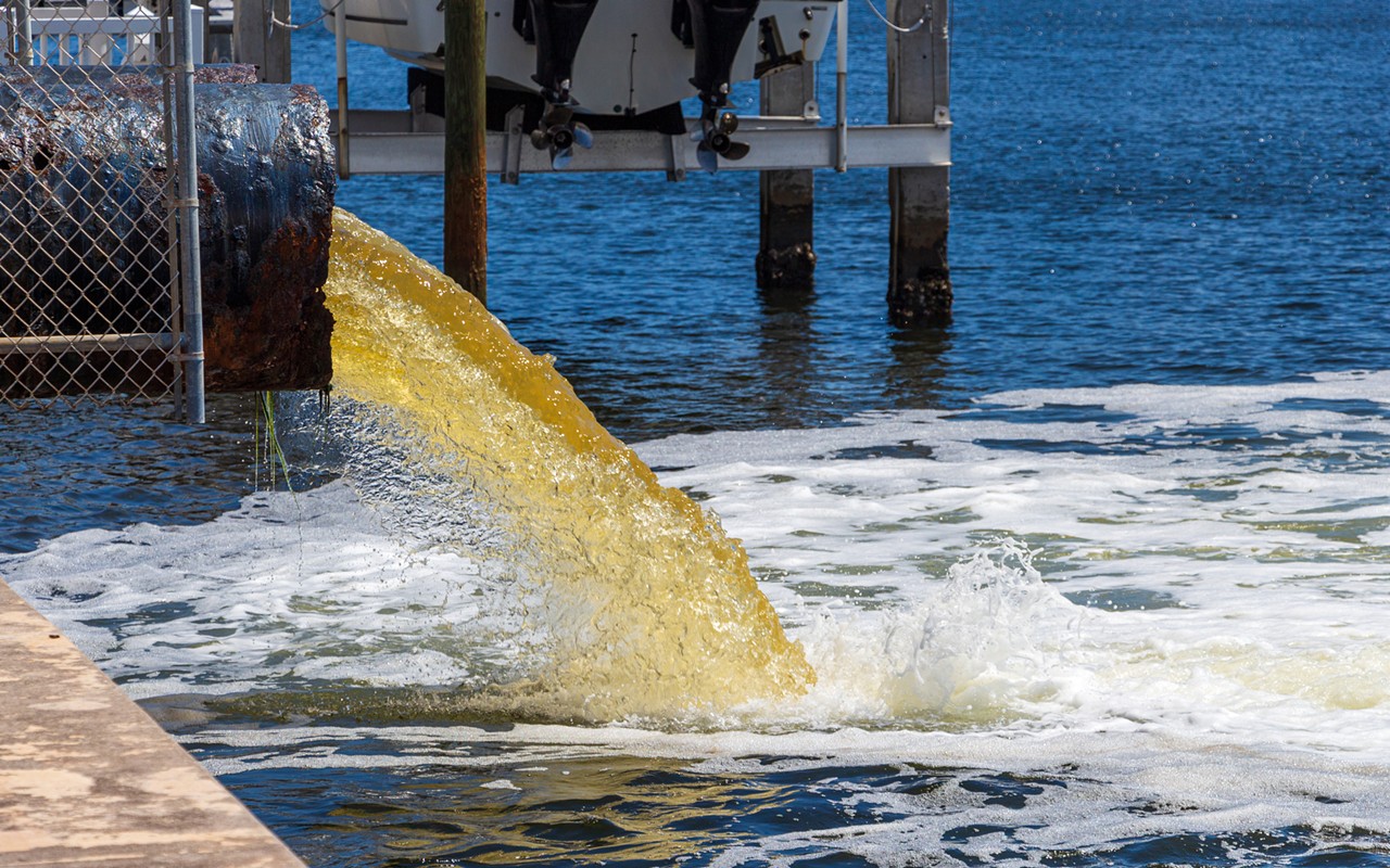 Raw untreated yellow water or sewage being pumped into a blue lake - Hollywood, Florida.