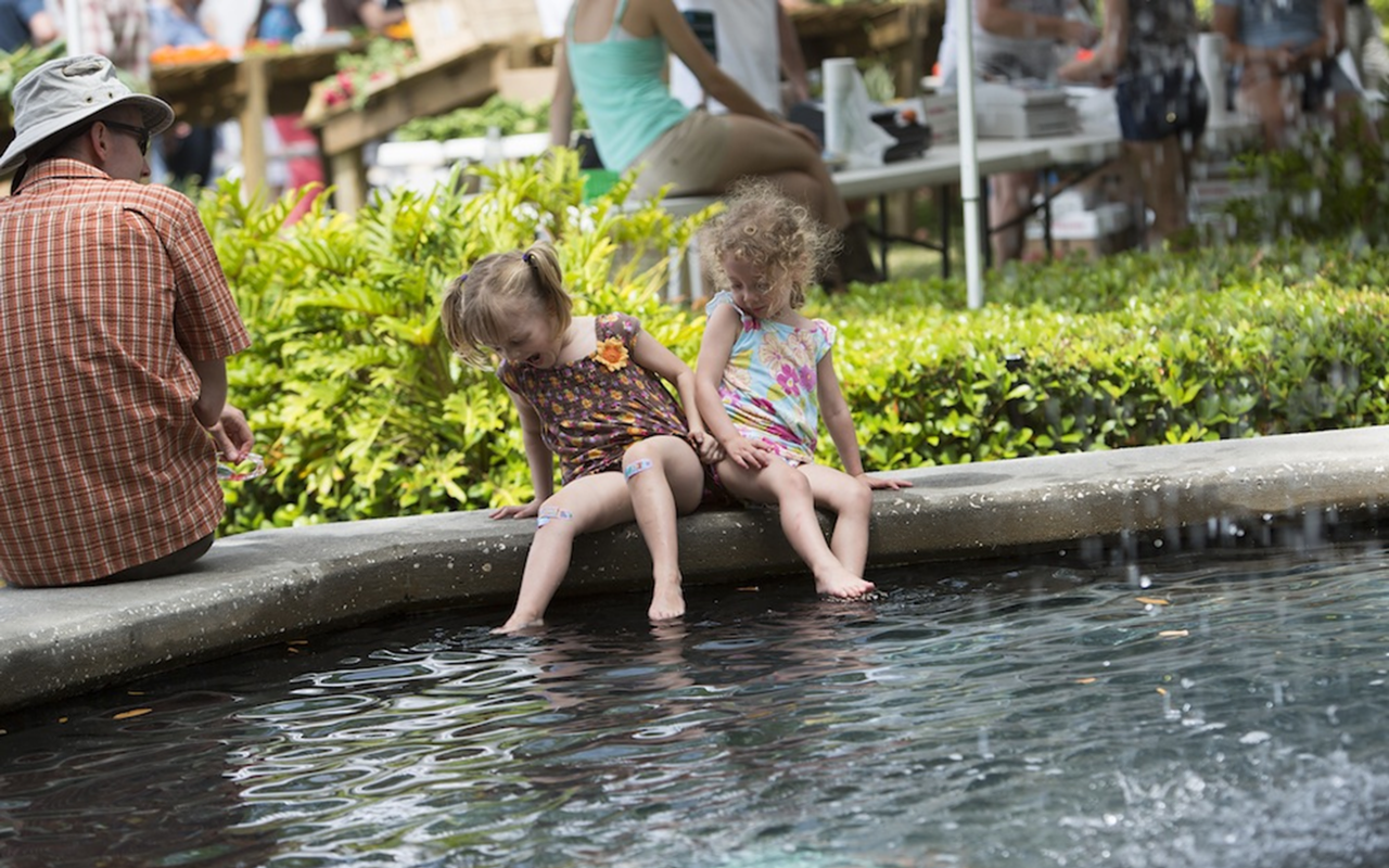 MAKING A SPLASH: Eva, 4, and Carmen, 2, cool off in the fountain while their dad looks on at the Hyde Park Market.