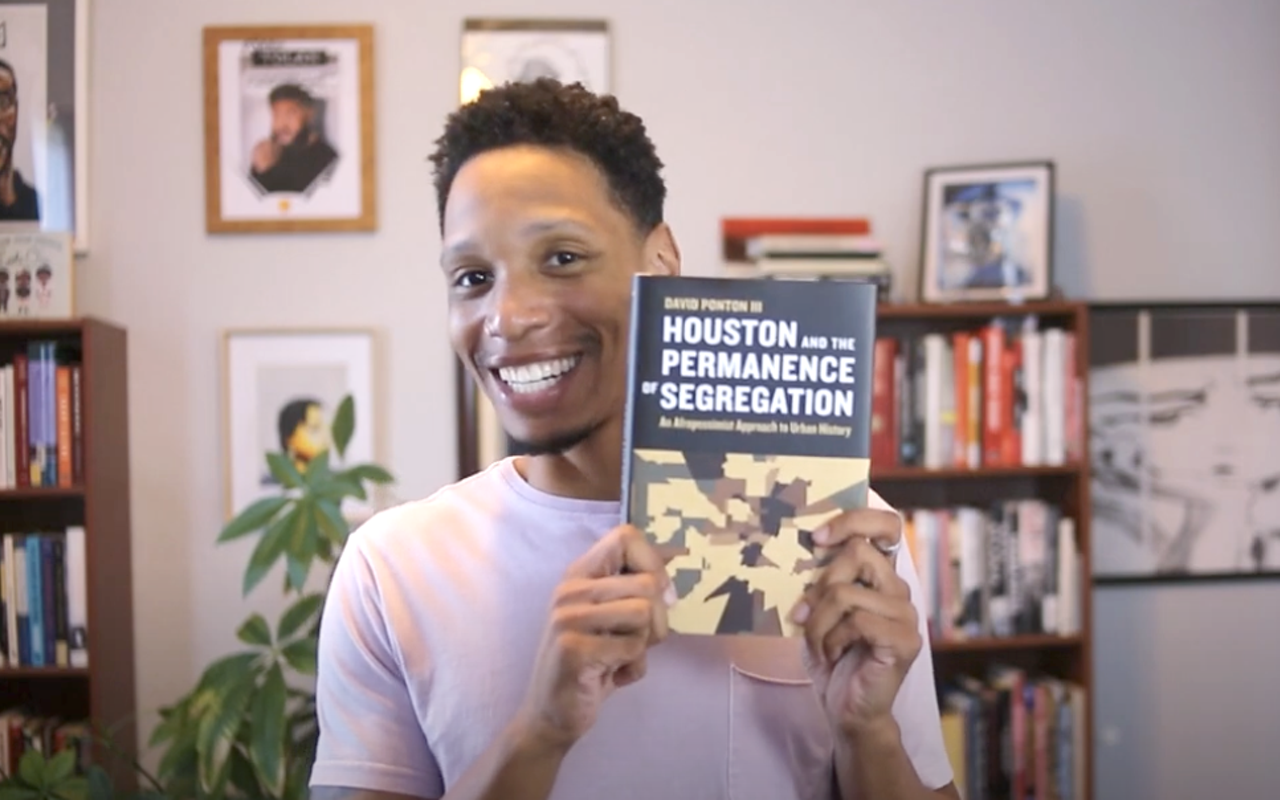 Profesor and author David Ponton gives a talk on Juneteenth and Pride in Tampa, Florida on Sunday, June 15, 2025. He's pictured here with his book "Houston and the Permanence of Segregation: An Afropessimist Approach to Urban History."