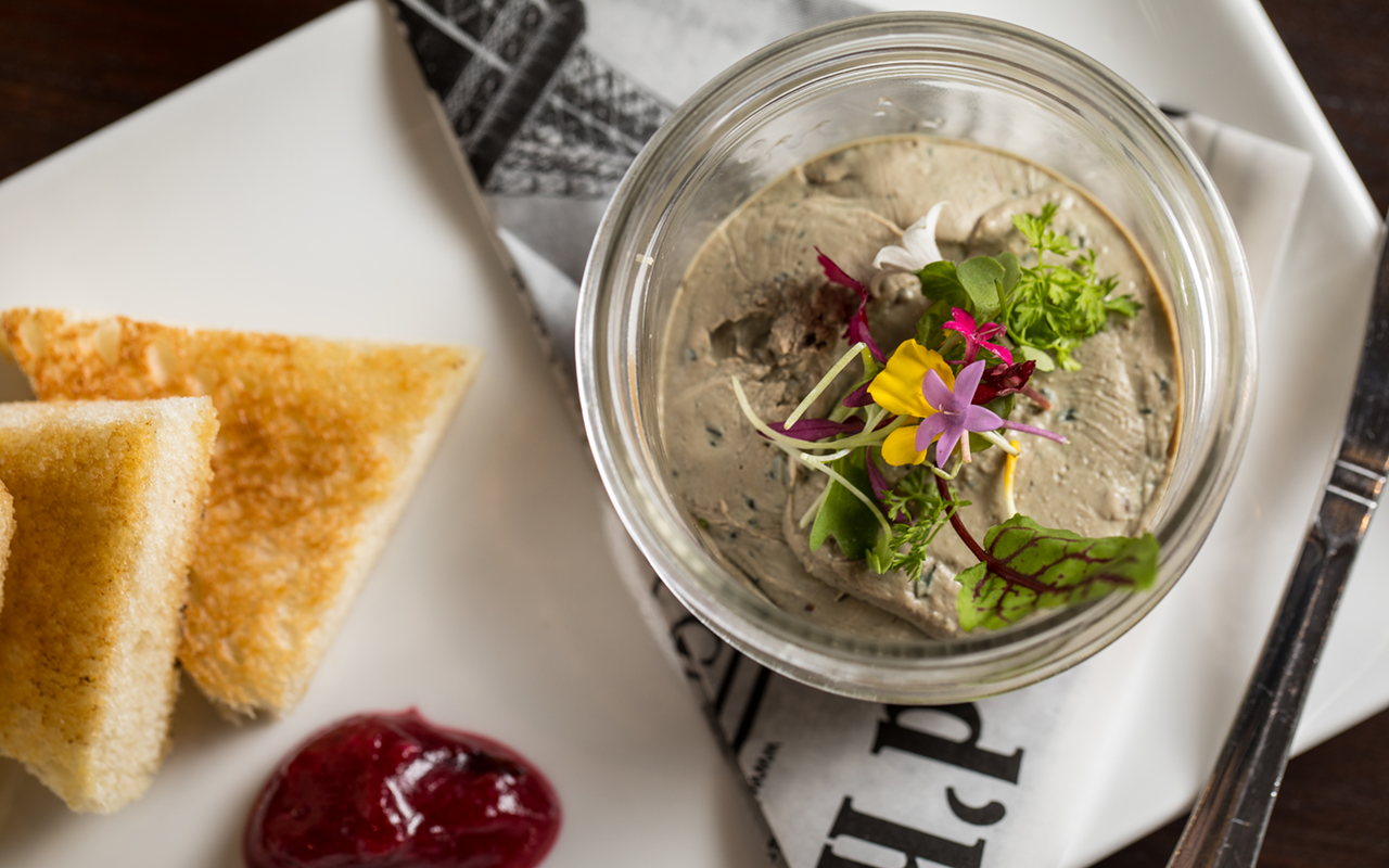 Chicken liver pâté is beautifully presented with toast triangles and a mound of onion marmalade.
