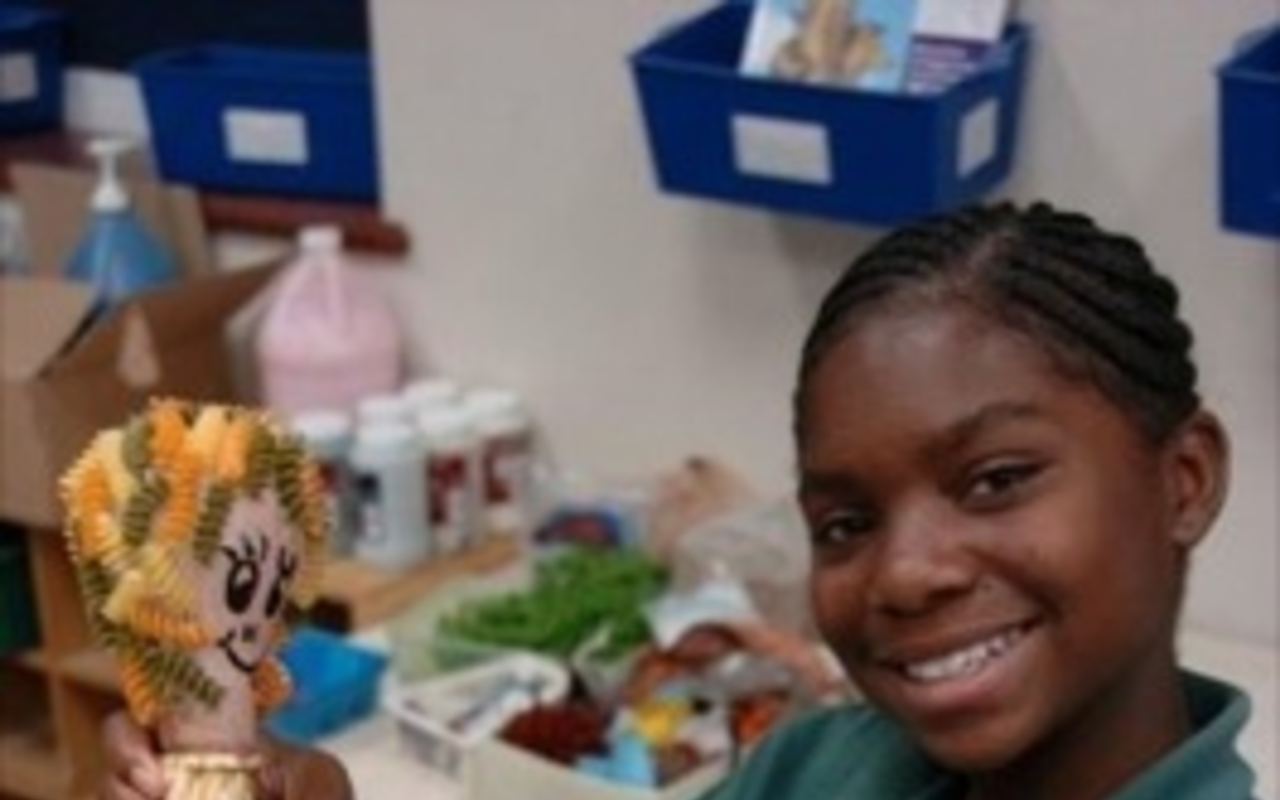 Academy Prep student Mikeisha Wilks with her light-bulb marionette.