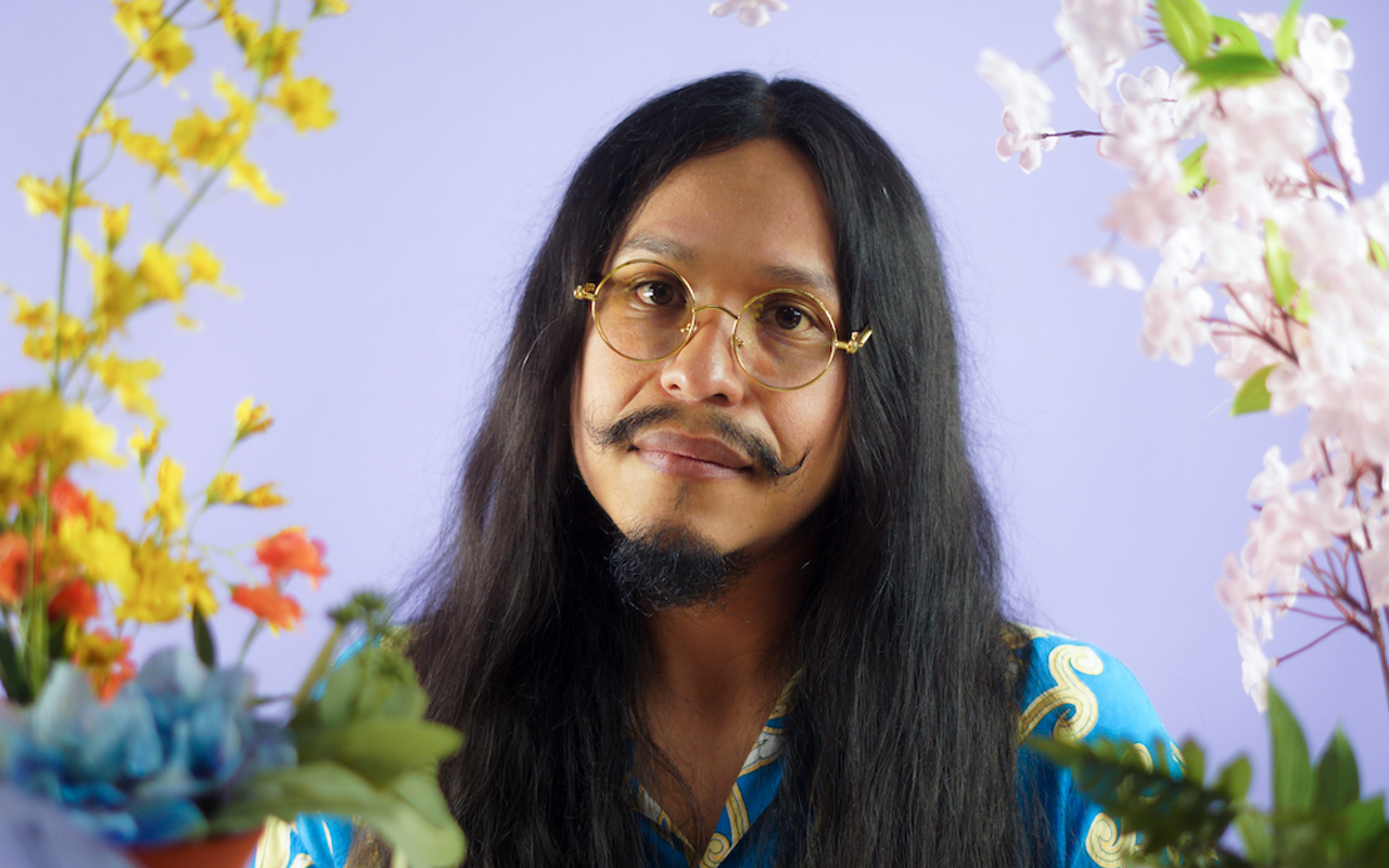 Photo of a musician with long black hair glasses and a really cool mustache