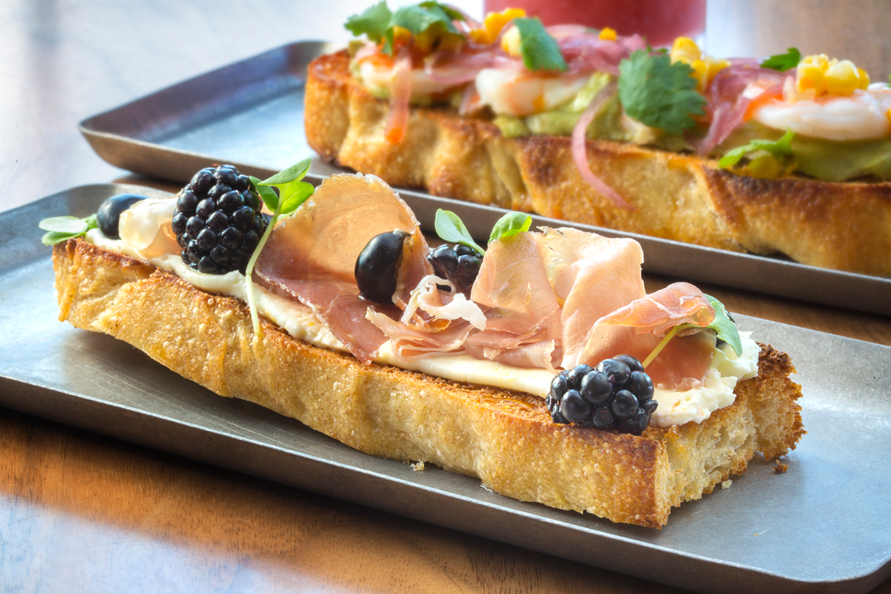 Another tartine features whipped goat cheese, blueberries and blackberries, fermented honey, prosciutto, and basil.