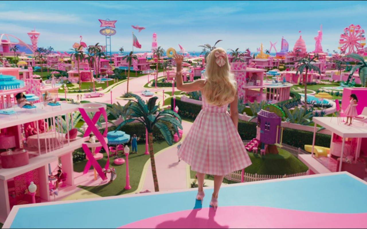 Barbie (Margot Robbie) waves good morning to the residents of Barbieland, a perfectly pink utopia where everyone is equal and capable and appreciated. Gasp! The horror!