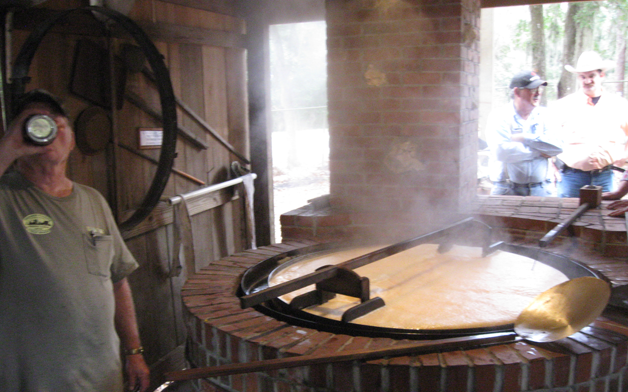 Boiling sugar cane juice to make syrup.