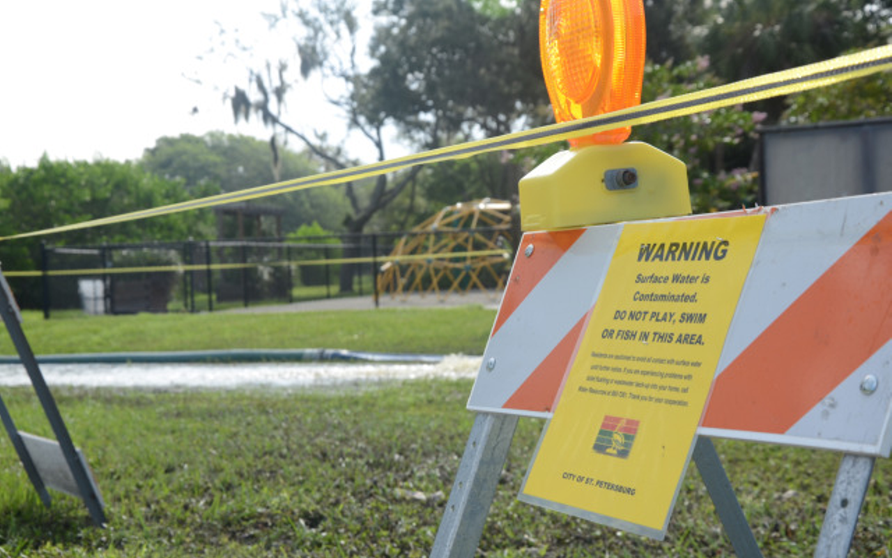 A sign and barricade warn of sewage being released into a local water, Clam Bayou, after weeks of heavy rain in the summer of 2015.