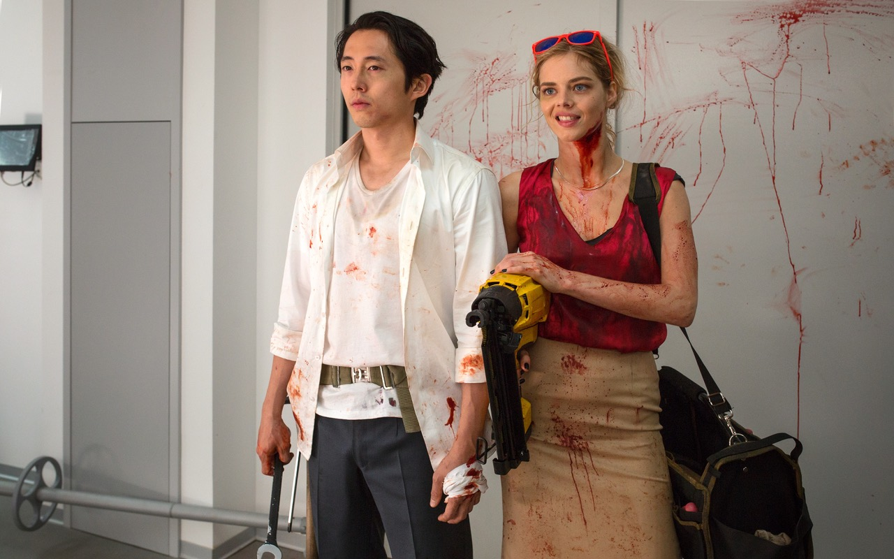 Steven Yeun, left, and Samara Weaving get their hands extra dirty fighting corporate corruption.