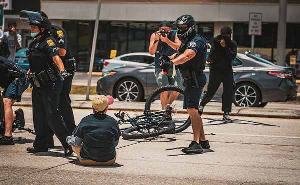 A Tampa police officer aims pepper spray at a Black Lives Matte protester in Tampa, Florida on July 4, 2020.