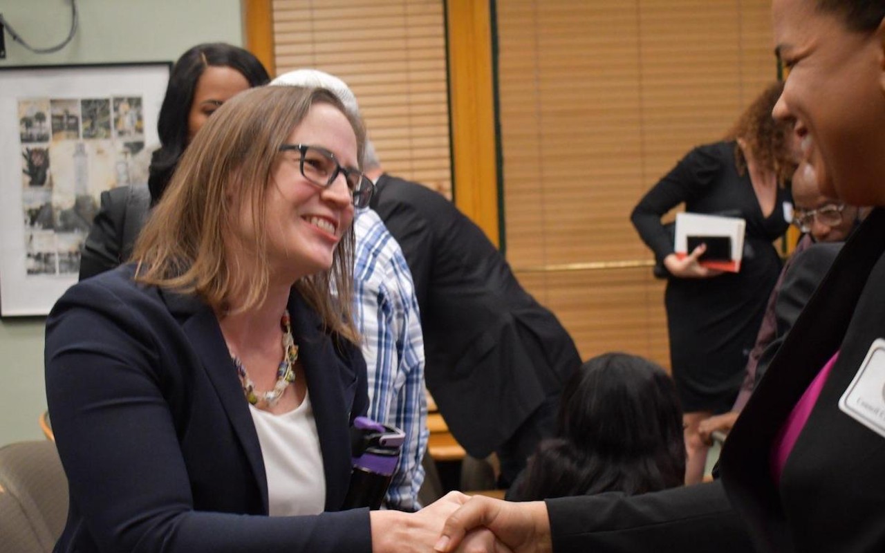 Lynn Hurtak (L) shakes hands with Meredith A. Freeman after city council's 4-2 vote to appoint Hurtak to the council, on April 5, 2022.