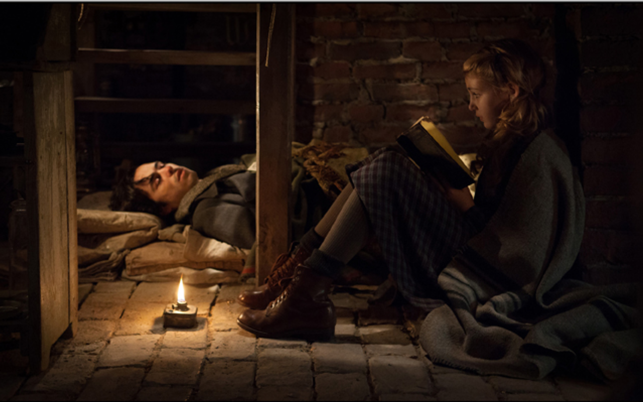 BOOK IT: Liesel (Sophie Nélisse) reads to Max (Ben Schnetzer), who’s hiding in her home.