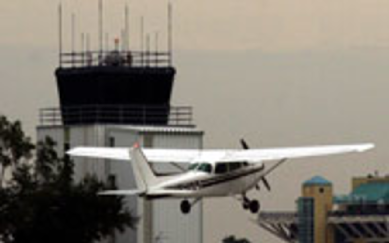 CITY GATEWAY: A plane takes off from Albert Whitted 
    with the control tower and St. Petersburgs downtown 
    landmark, The Pier, in the background.