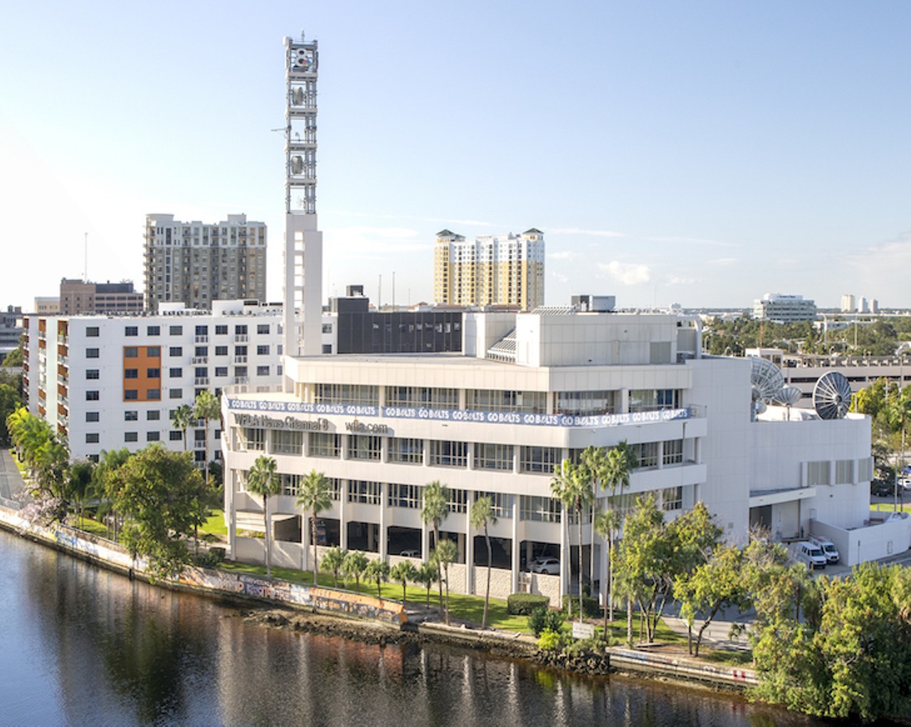 NOW
WFLA News Channel 8 building
Manor Riverwalk Apartments in the background, 2020.
In 2016 the Tampa Bay Times purchased the Tampa Tribune following years of declining subscriptions and the advent of the digital revolution. It was the end of a 121-year-old daily newspaper that started as the Tampa Morning Tribune in 1893. The Tribune building once stood where the eight story Manor Riverwalk apartment complex (white building with orange design in the background) now stands. Pictured here is the 145,000 sq ft building that houses WFLA News Channel 8. Special thanks to the Sheraton Tampa Riverwalk Hotel for granting access for this photograph.