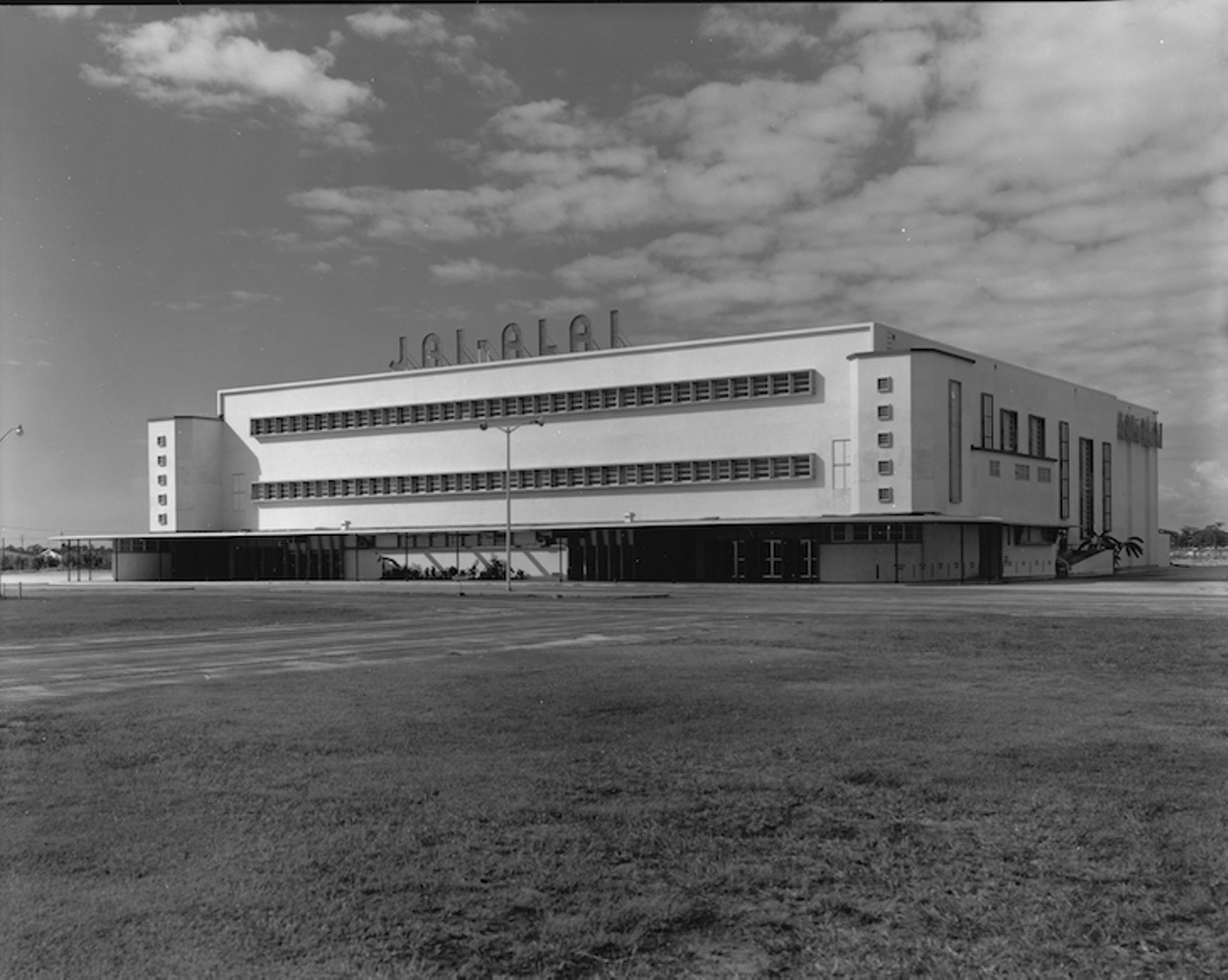 THEN
Tampa Jai-Alai Fronton building
5125 South Dale Mabry Highway, 1955. 
Jai Alai is a game brought to the United States from Cuba but had to fight for years to get established in Tampa due to parimutuel wagering laws. Played with a ball about the size and hardness of a golf ball and hurled against the wall, opponents had to catch the speeding sphere in long baskets (called cestas) tied to players hands. Customers wagered on the outcome of the game. The original site for Tampa Jai Alai was planned for just south of Henderson Boulevard on Dale Mabry, but was scrapped due to objections from residents and potential neighbor Christ the King Catholic Church. Opening in 1953 on Dale Mabry just south of Gandy, it was the second Jai Alai fronton in the country. Matches were played seasonally for years until innuendo arose that the games were fixed. The decline of the frontons popularity was compounded by the arrival of other competitive sports teams in Tampa, and gambling available at the new Seminole Casino. The last game at the 4000-seat Tampa Jai-Alai fronton was played on July 4, 1979.