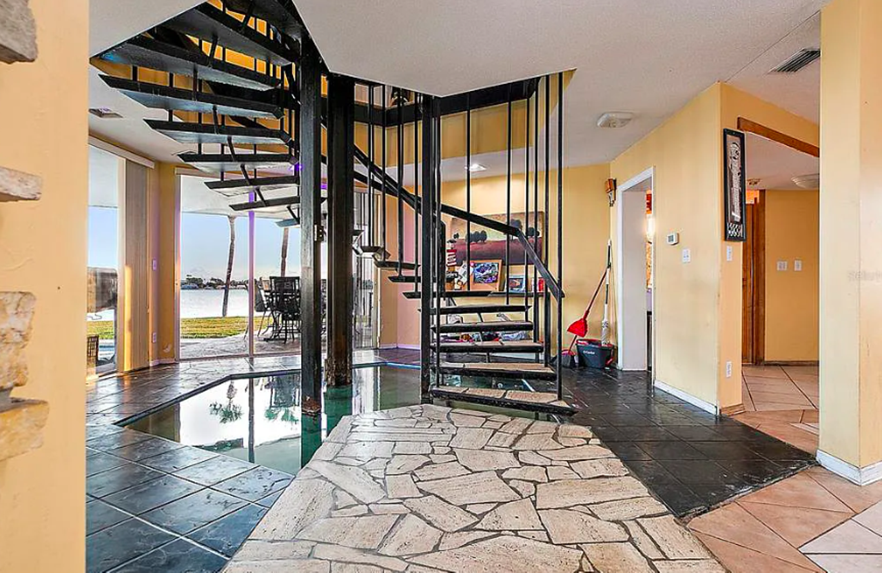 This Tampa Bay home sits on its own 2-acre peninsula and comes with an indoor koi pond and a bird-cage elevator