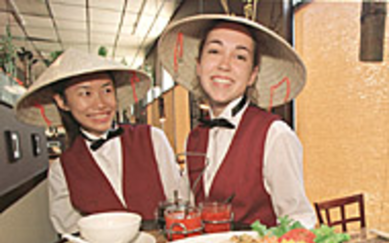 JUST DUCKY: From left, Bamboo Flute servers Anne Nguyen and 
    Kristen Bowman serve up a generous portion  of Thang Long Duck.
    <p