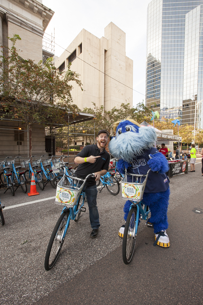 Eric Trull, program director of Coast Bike Share, was all smiles before losing a bicycle race to Rays mascot Raymond. - Nicole Abbett