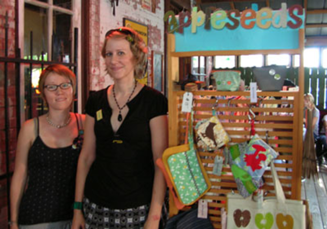 CRAFTY WOMEN: Meli Mossey (left) and Alison Odowski in front of Alison's Appleseeds display at New World Brewery. - Megan Voeller