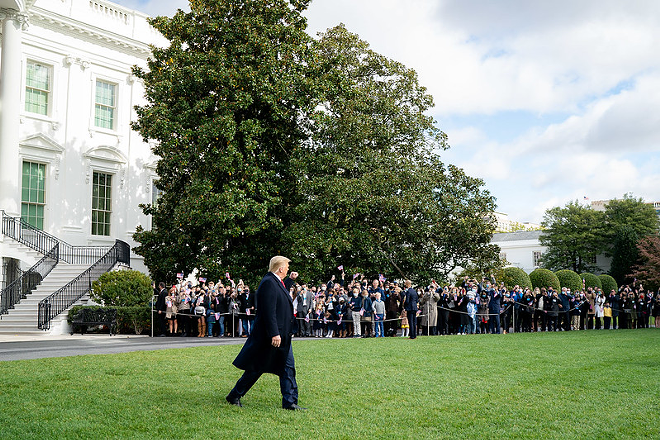 President Donald J. Trump gives a fist bump to supporters Friday, Oct. 30, 2020, prior to boarding Marine One en route to Joint Base Andrews, Md. to begin his trip to Michigan, Wisconsin and Minnesota. - Official White House Photo by Tia Dufour