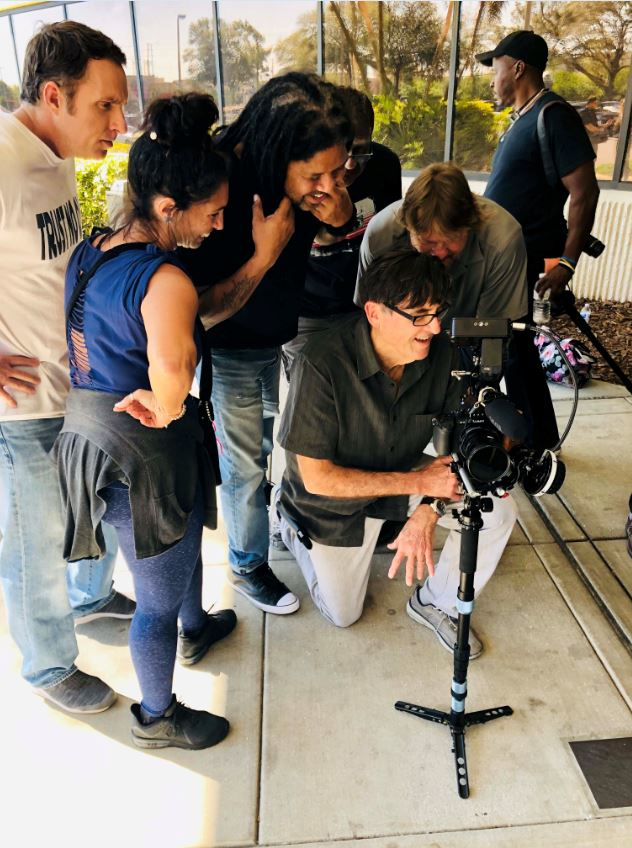 Maurice Jovan, center, looks on with Curtis Graham, cinematographer, and other cast and crew while filming "W.D.E.D." - SPIKE SLATER