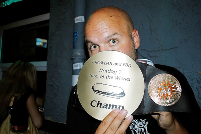 HOT DOG HERO: Two-time hot dog eating champion Keegan Maloney brandishing his second belt at Crowbar Wednesday. - JESSICA MOORE
