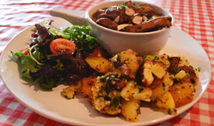 A pork stew with prunes and almonds, porc aux pruneaux comes with potatoes, salad and soup. - TYLER GILLESPIE