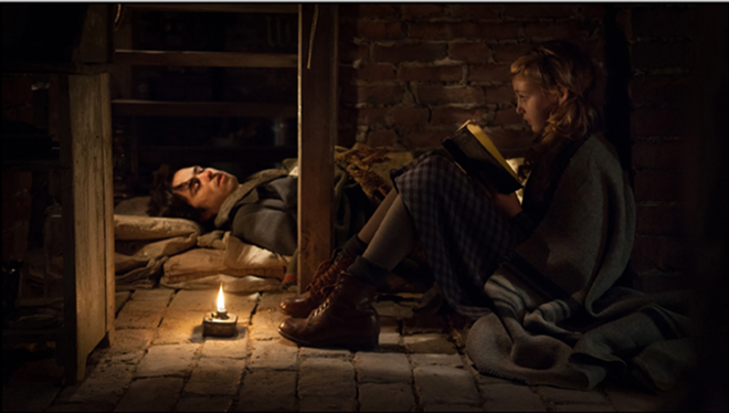 BOOK IT: Liesel (Sophie Nélisse) reads to Max (Ben Schnetzer), who’s hiding in her home. - Jules Heath