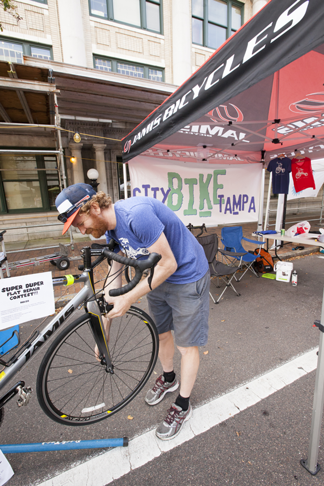 Christian Carlquist of City Bike preparing for their flat tire contest. Cyclovia Tampa 2015. - Nicole Abbett