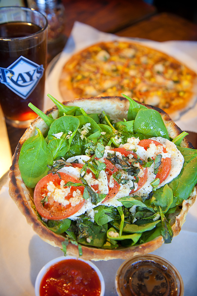 OPTIONS: The caprese salad, foreground, is served in a baked pizza-dough bowl; the Hippie’s Pie toppings include tofu, spinach and sun-dried tomato basil sauce. - Shanna Gillette