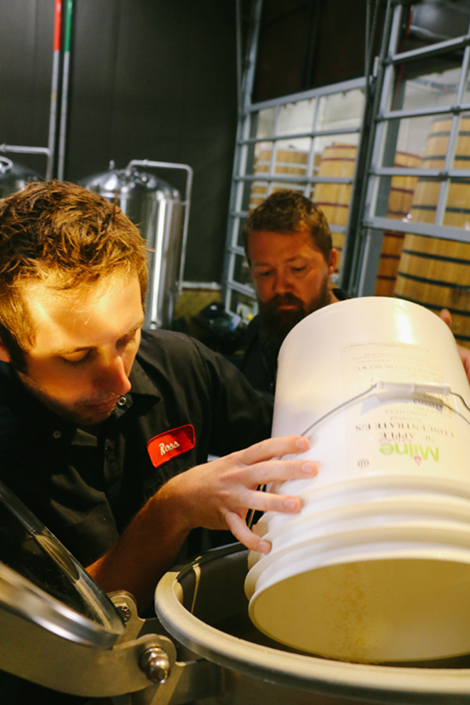 New Belgium brewer Ross Koenigs and Eric Trinosky, lead brewer at Cycle Brewing, monitor their brew. - New Belgium Brewing