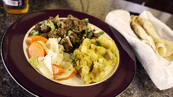 RANDY’S ROTI: The open-faced curry goat with curry potatoes, steamed cabbage and a basket of homemade roti bread. - Arielle Stevenson