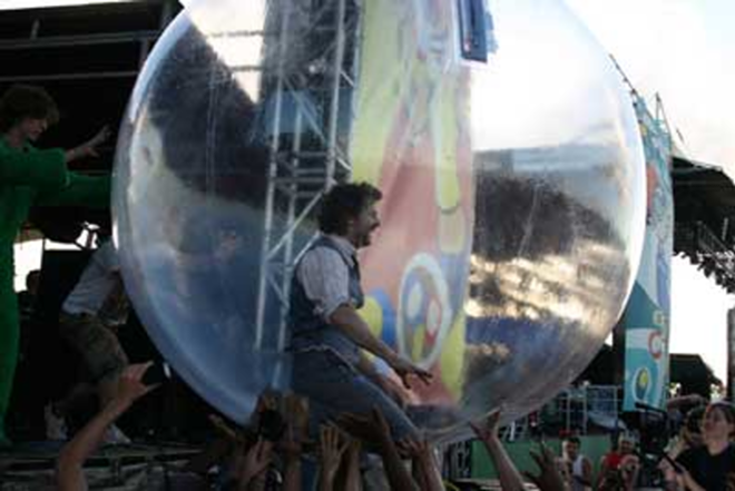 The Flaming Lips' ringmaster Wayne Coyne walking (and falling) on the crowd in a giant plastic bubble. - Phil Bardi