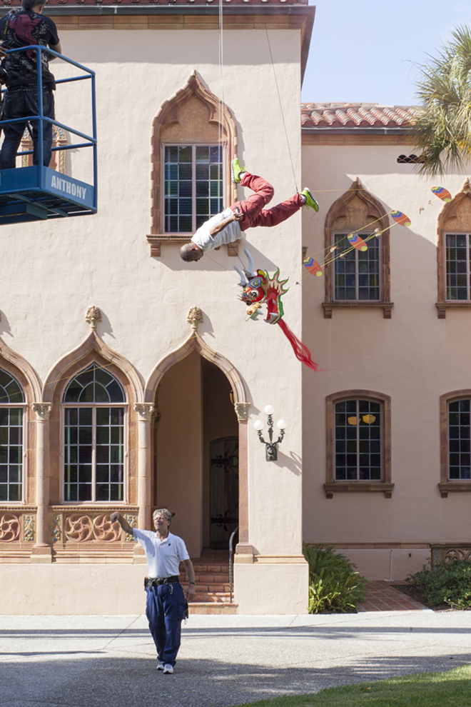 Chinese artist Li Wei soars 40 ft in the air, using the Cá d’Zan as a backdrop for his art at The Ringling. - Nicole Abbett