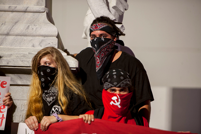 Some protesters wear bandanas over part of their faces to conceal their identity. - Kimberly DeFalco