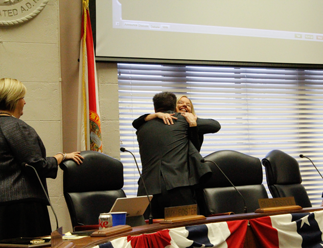 Newly inaugurated St. Petersburg Councilwoman Gina Driscoll hugs new colleague Steve Kornell as Amy Foster, another new colleague, looks on. - Dinorah Prevost