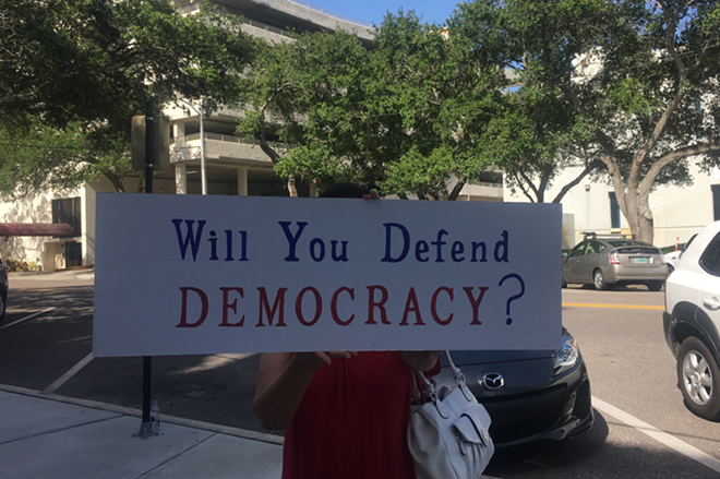An anonymous demonstrator holds a sign ahead of the council's decision. Proponents of the measure to limit shady money in local elections gathered on the steps of St. Pete City Hall Thursday morning to voice their support for the proposal. - Kate Bradshaw