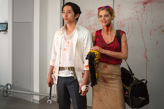 Steven Yeun, left, and Samara Weaving get their hands extra dirty fighting corporate corruption. - RLJE Films