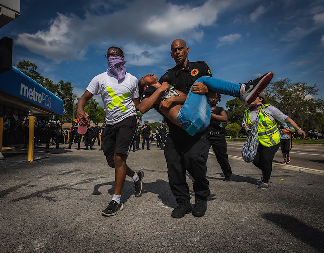 A member of the New Black Panther Party helps a protestor in Tampa, Florida on May 31, 2020. - Dave Decker