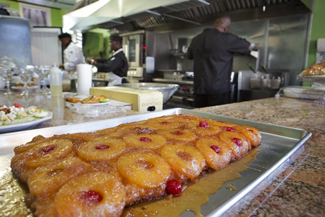 Pineapple upside-down cake awaits diners as chefs cook in the open kitchen. - Chip Weiner