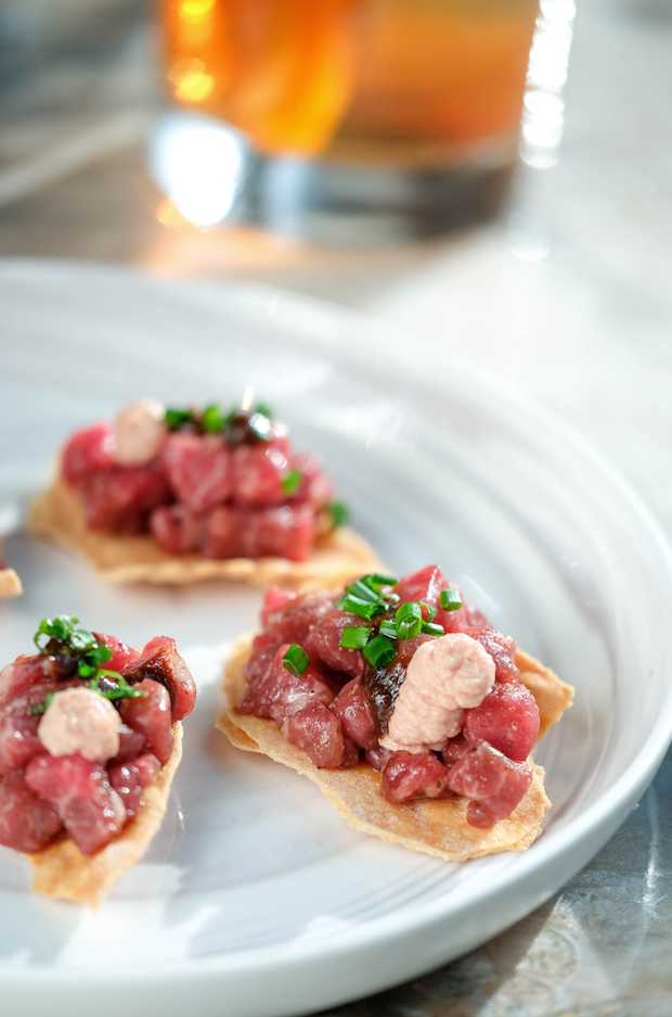 The tartare amuse bouche sits on a small papadum-type cracker topped only with salt, pepper, and a dot of fermented garlic. - Melissa Santell