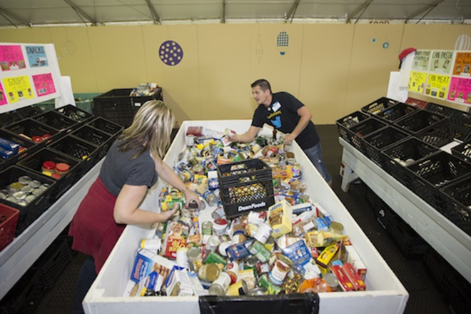 Volunteers sort food into bins at the Metropolitan Ministries Holiday Tent in Tampa Heights, which opens to the public Nov. 20. - Chip Weiner