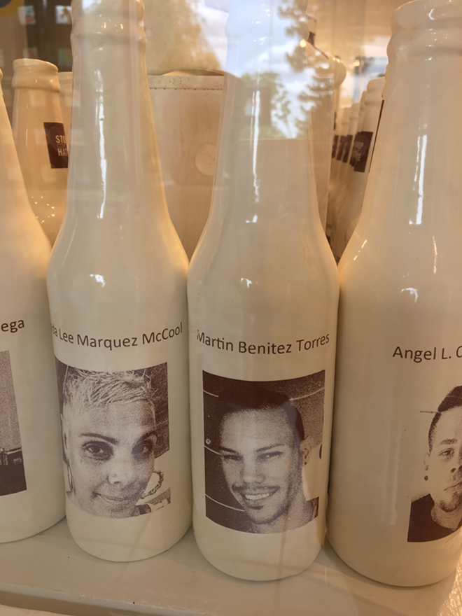 Each milk bottle has the name and photo of a Pulse victim. - Photo by Cathy Salustri