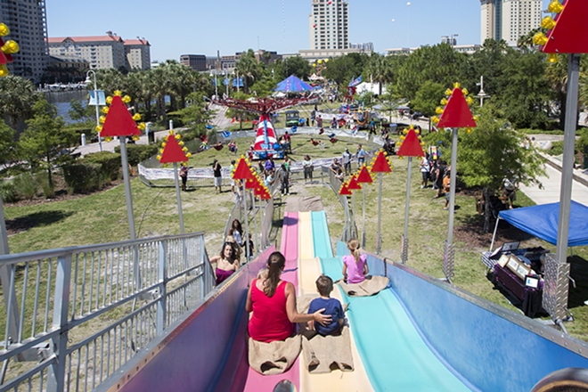 Carnival goers descend down the giant slide into content  Cotanchobee Park as part of the first Downtown Tampa Carnival. - CHIP WEINER