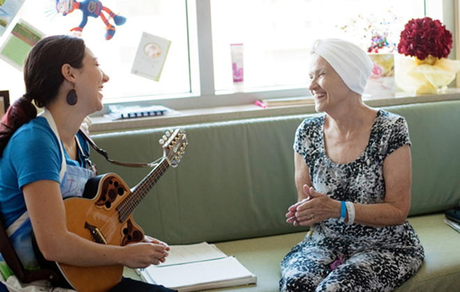 HEALTHY DISTRACTION: Danielle DeCosmo sings with a patient at Shands Hospital at the University of Florida (patient name unknown). - Maria De Lordes